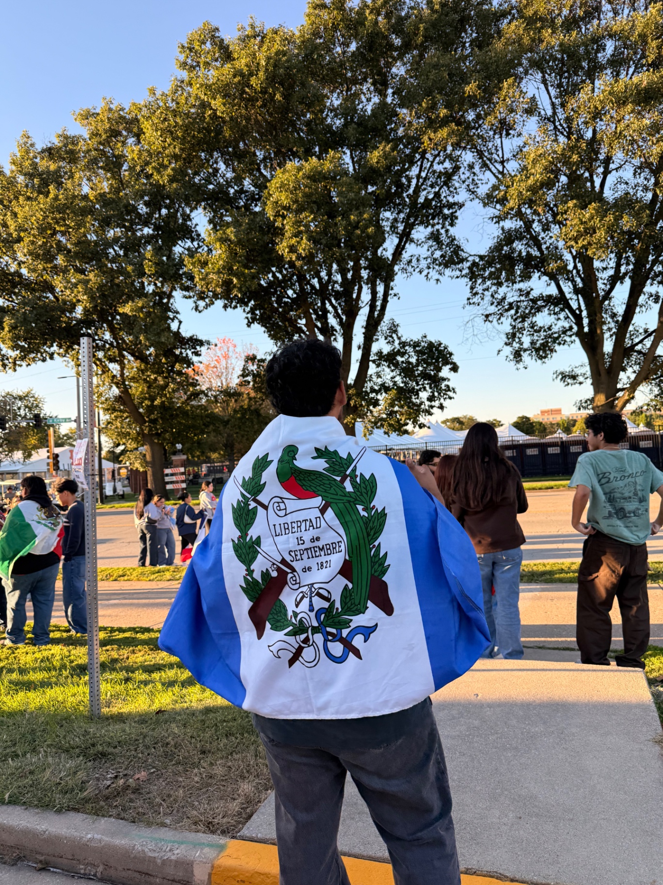 Chris Guzaro seen from behind wearing the Guatemalan flag at the University of Illinois Urbana-Champaign